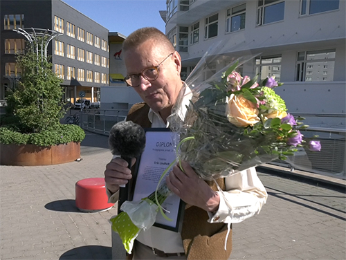 Erik Lindfelt with flowers and diploma