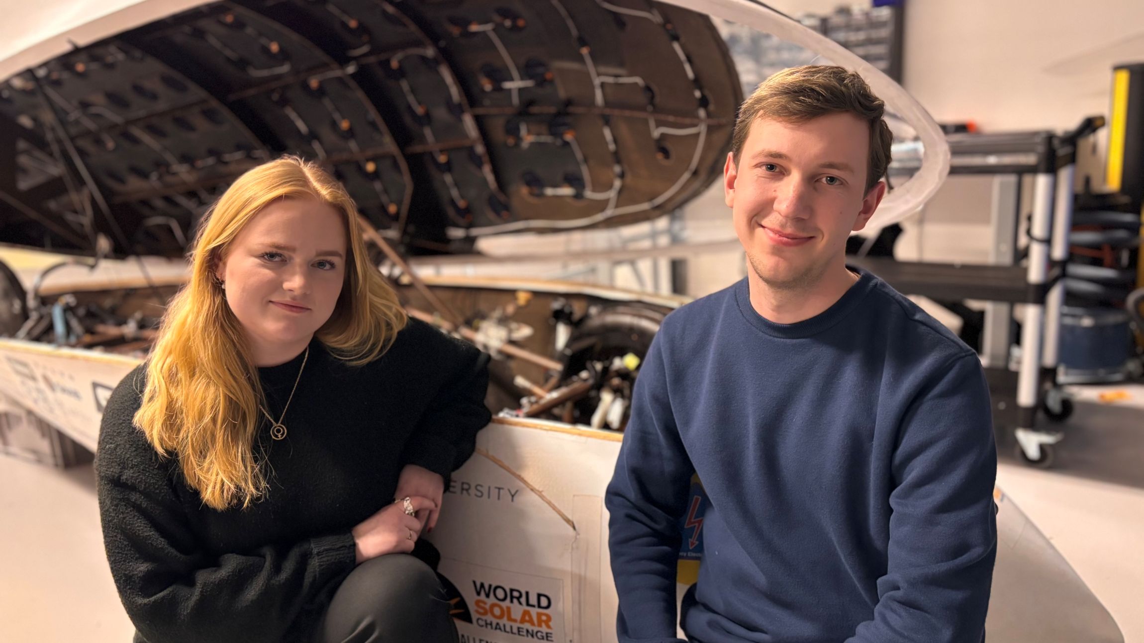 Studenter in front of a solar car.