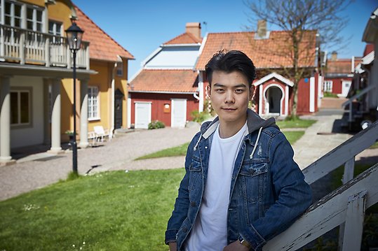 Portrait photo of man with small houses in the background