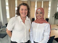 Två women standing next to eachother.