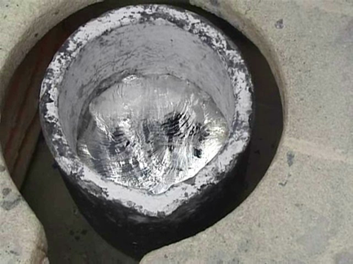 Close up of melted aluminium slurry in a casting bowl. 